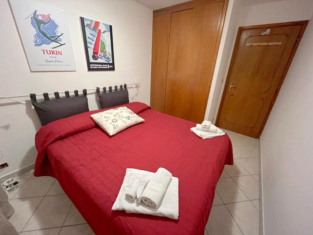 une chambre avec un lit rouge avec des serviettes dessus dans l'établissement Casa Rossa - Italian Style in Sestriere, à Sestrières