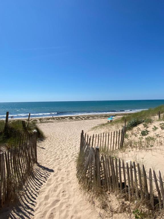 a wooden fence on a beach with the ocean at ancienne ferme maison familiale in Chaucre