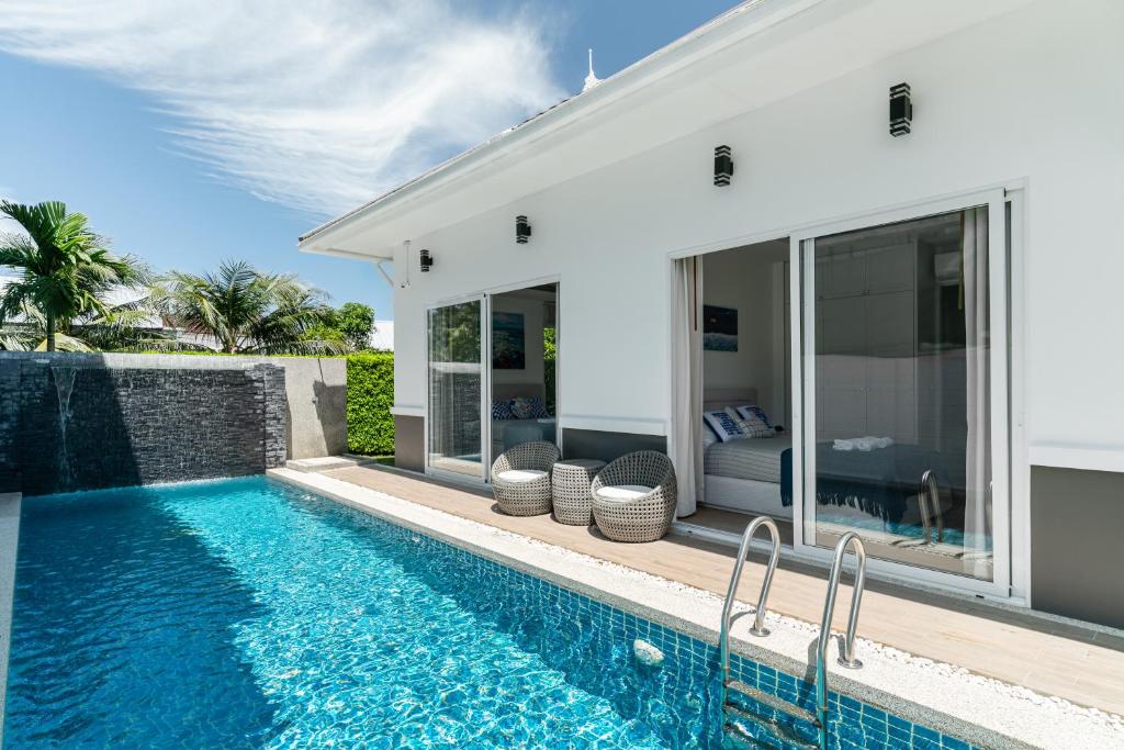 a villa with a swimming pool and a house at Friendly Kamala Garden View in Kamala Beach