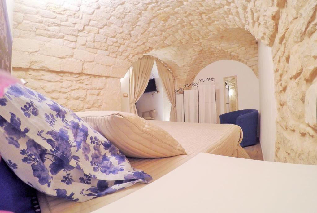 a bedroom with two beds in a stone wall at Al Borgo dell'Arte Suite in Scicli