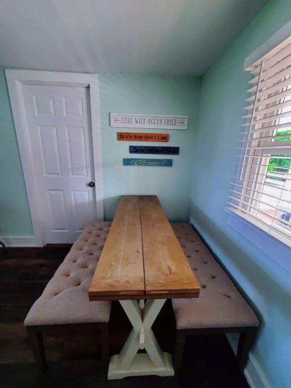 a wooden table in a room with a door at Pet friendly minutes to beach in Marlyn Manor