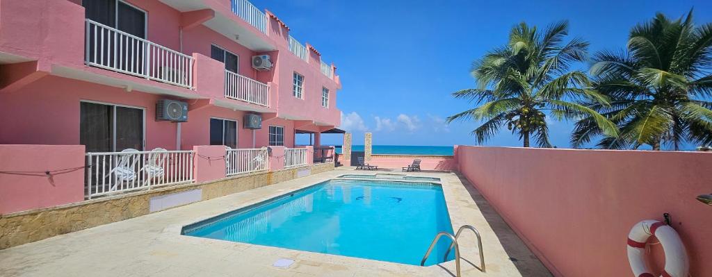 una piscina frente a un edificio rosa en Selva Boutique Hotel - Luquillo Oceanfront Retreat - Adults Only, en Luquillo