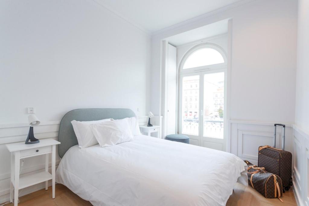 a white bedroom with a bed and a window at Boulevard Lisbon Bedrooms in Lisbon
