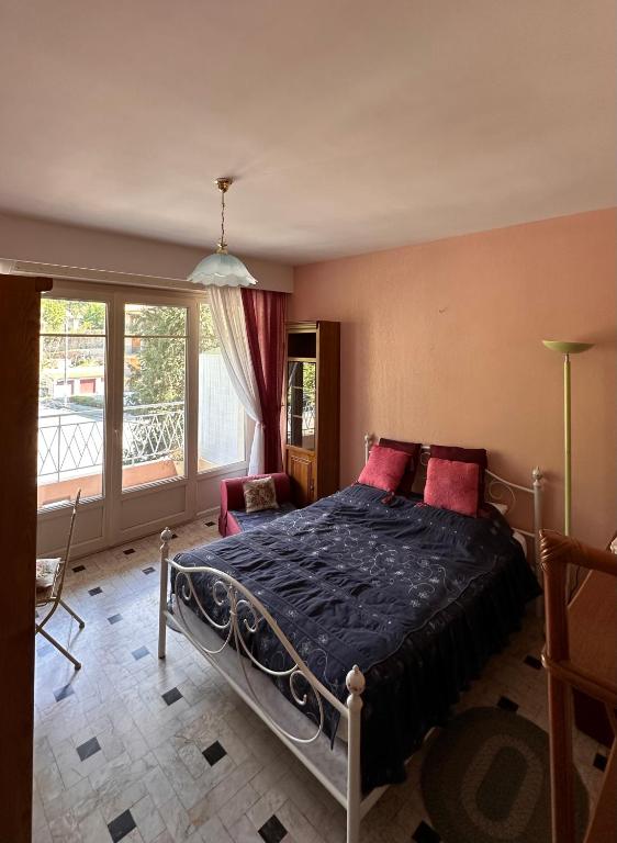 une chambre avec un lit et une grande fenêtre dans l'établissement Appartement Le Palais, à Vernet-les-Bains
