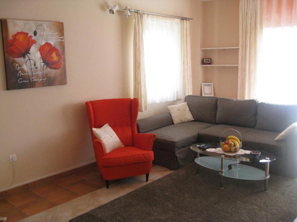 a living room with a couch and a red chair at Dina Apartments in Pula