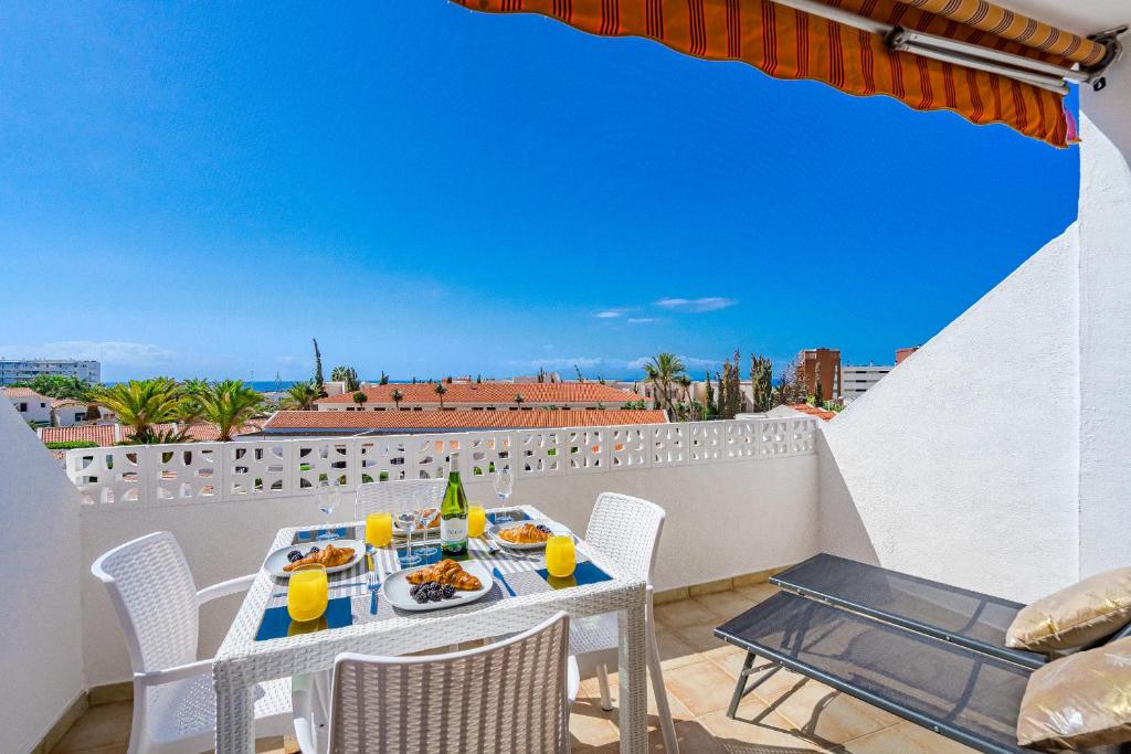 a table and chairs on a balcony with a view at Costa Adeje Heated Pool Marina Primavera in Adeje