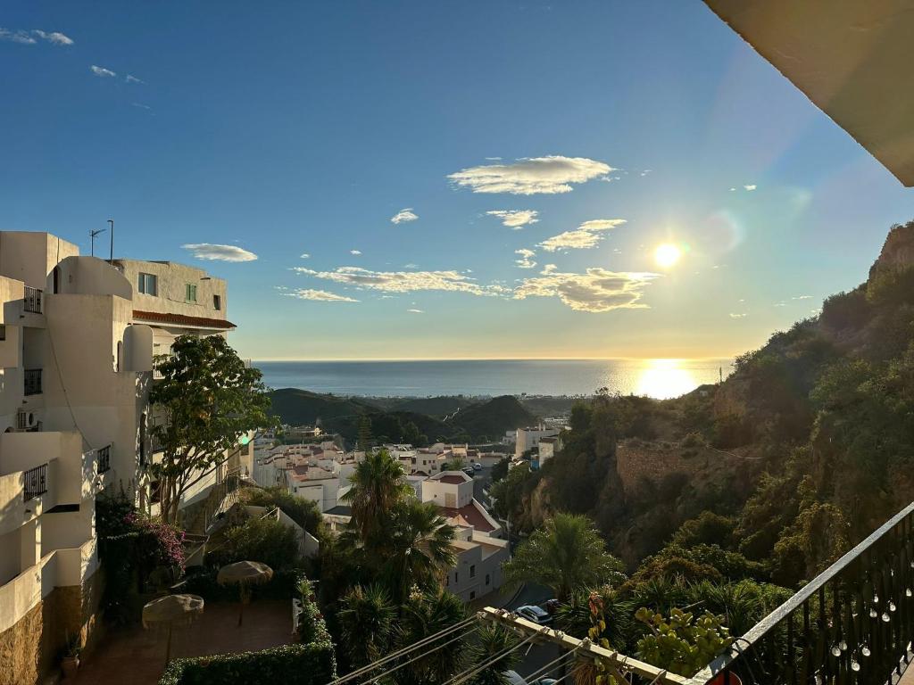 a view of a city from a balcony with the sun setting at Apartamento El Cortijo in Mojácar
