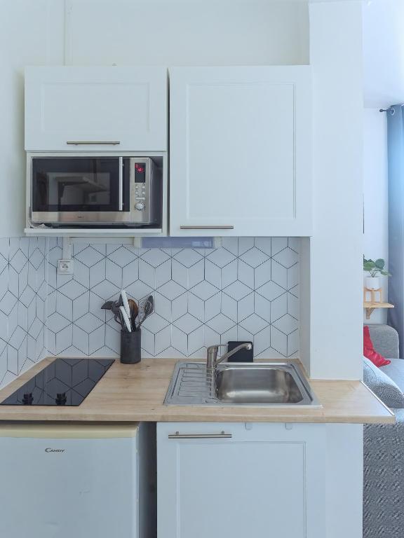 kuchnia ze zlewem i kuchenką mikrofalową w obiekcie L'escale cosy - Nogent Le Rotrou - Proche gare w mieście Nogent-le-Rotrou