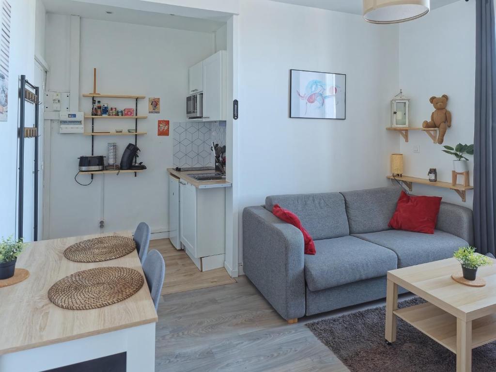 salon z kanapą i stołem w obiekcie L'escale cosy - Nogent Le Rotrou - Proche gare w mieście Nogent-le-Rotrou