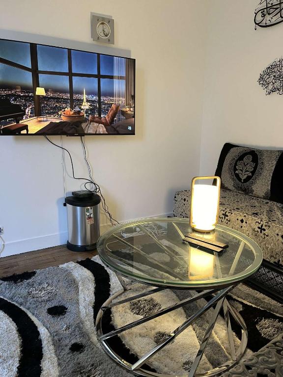 un salon avec une table en verre et un canapé dans l'établissement Appartement proche Montparnasse et Port Royal, à Paris