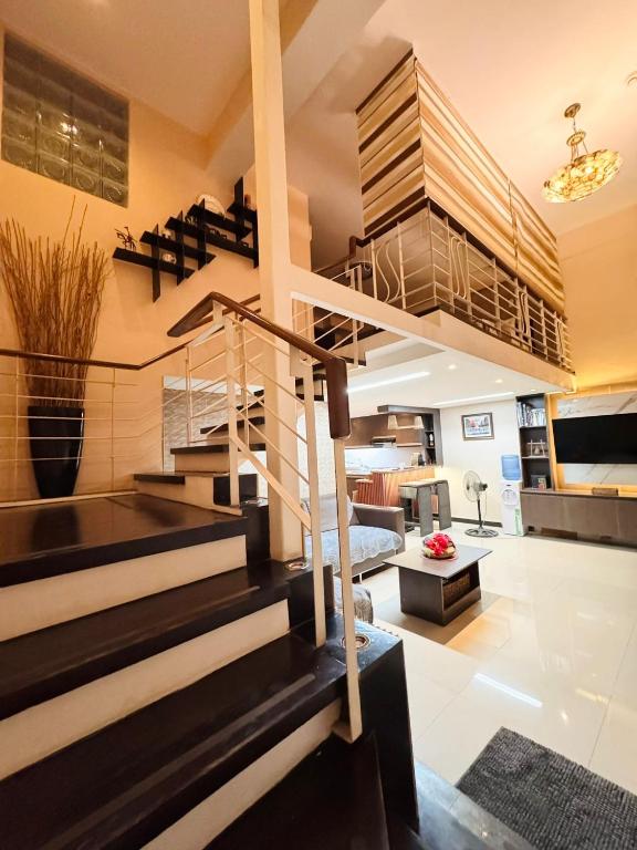 a living room with a spiral staircase in a house at Super Cebu Loft in Cebu City