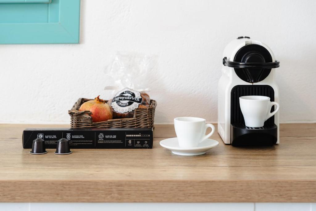 a coffee maker and a basket of fruit on a counter at Ploes Seaside Houses in Plaka