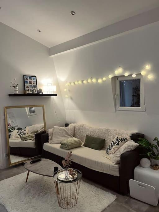 un salon avec un canapé et un miroir dans l'établissement Appartement T2 - Vue Tour Eiffel, à Paris