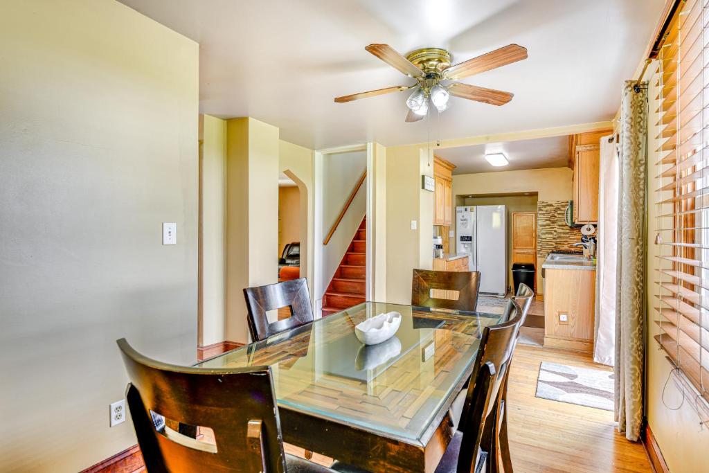 a dining room with a glass table and a ceiling fan at 2 Mi to Walden Galleria Home with Furnished Deck! in Cheektowaga
