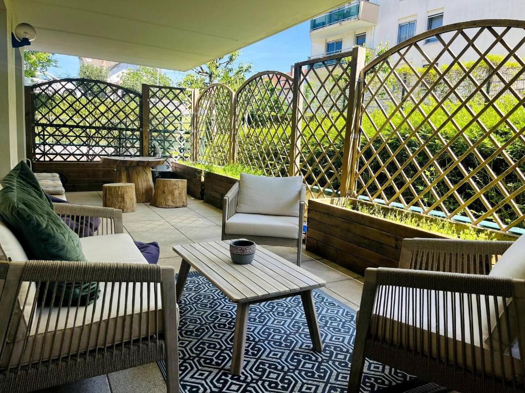 un patio avec des chaises et une table et une clôture dans l'établissement Résidence Aquarelle, appartement spacieux et chaleureux, grande terrasse, à Besançon