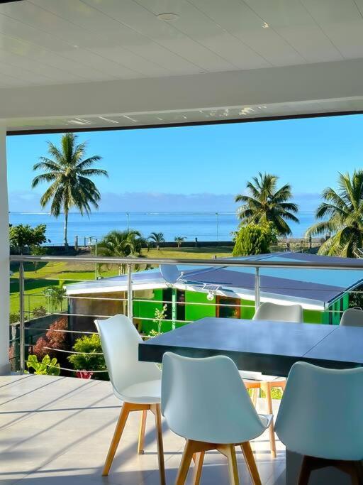 a table and chairs on a balcony with a view of the ocean at Teahupoo MANA VILLA in Toanoano