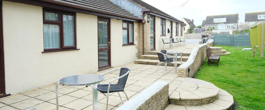 a patio with chairs and tables and a building at The Old Rectory - Brean in Brean