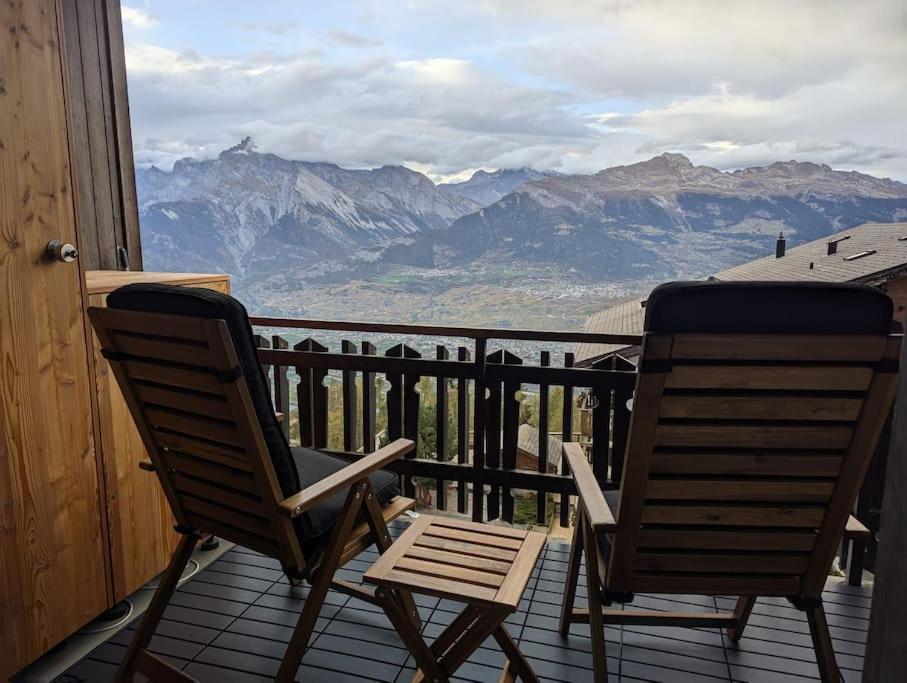 two chairs sitting on a porch with a view of mountains at Studio Le Chamois - Veysonnaz in Veysonnaz