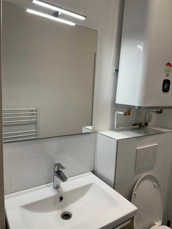 une salle de bain blanche avec un lavabo et un miroir dans l'établissement Ete Nice, à Nice