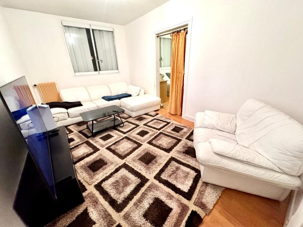 - un salon doté d'un mobilier blanc et d'un tapis dans l'établissement La source appart, à Orléans