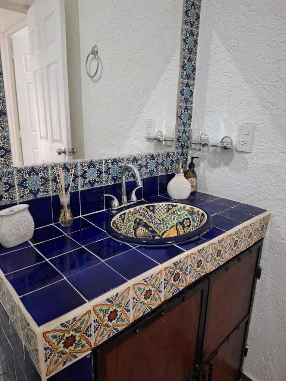 eine Badezimmerablage mit Waschbecken und Spiegel in der Unterkunft Villa los Pepe's in Puerto Morelos