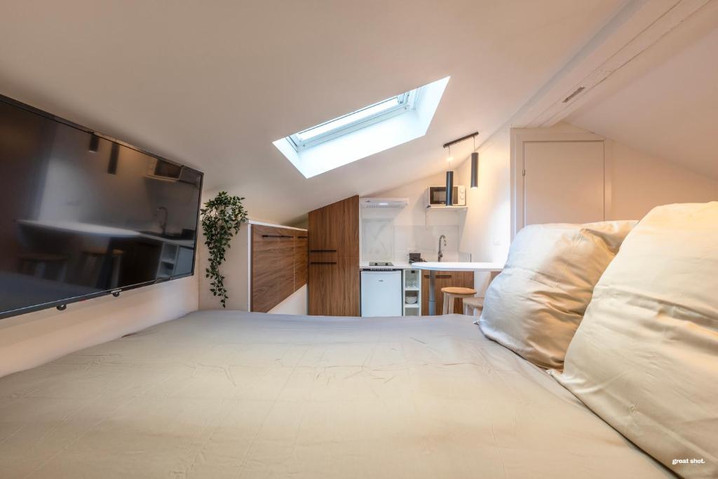 Cette chambre comprend un grand lit et une cuisine. dans l'établissement Montsejour - Magnifique studio neuf, à Toulouse