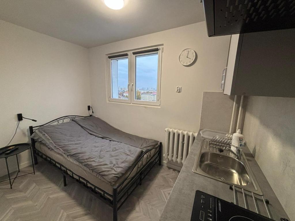 a small bedroom with a bed and a sink at Apartamenty w centrum Głogowa in Głogów