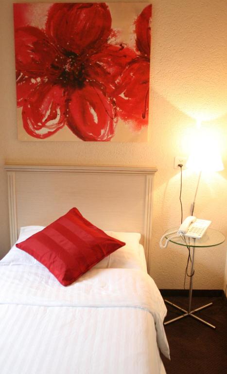 a bedroom with a red pillow on a white bed at Hotel Neufeld in Zürich