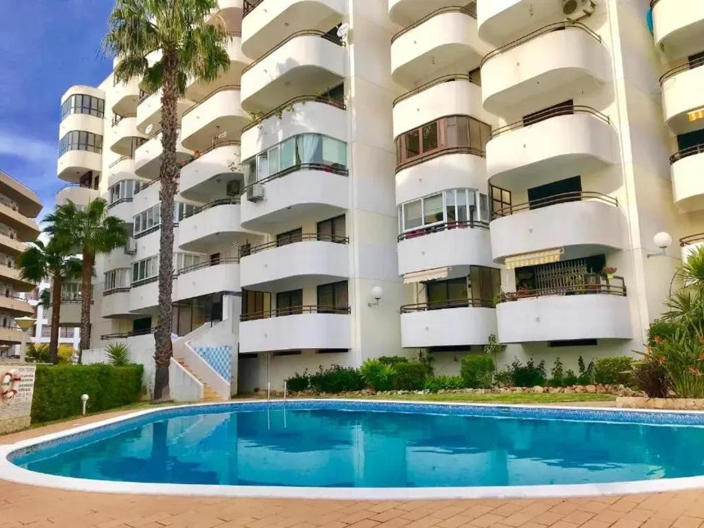 an apartment building with a swimming pool in front of it at Modern apartment in Vilamoura with shared pool in Vilamoura