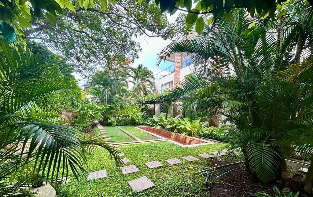 un jardin avec des palmiers et un bâtiment dans l'établissement Best Location & Comfort in the Walled City, à Carthagène des Indes