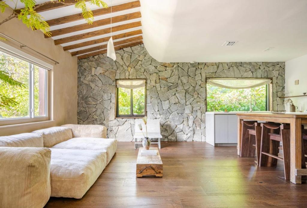 a living room with a couch and a stone wall at Casa Ishi - at lumicollection in Miami