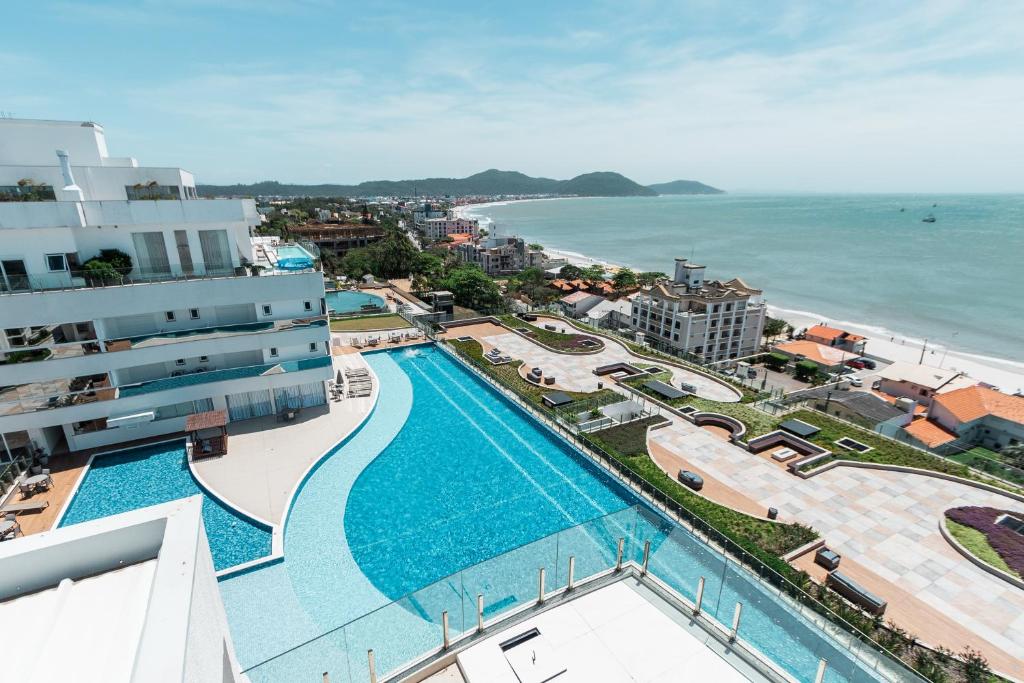 an aerial view of a resort with a swimming pool and the ocean at Conforto à beira-mar in Florianópolis