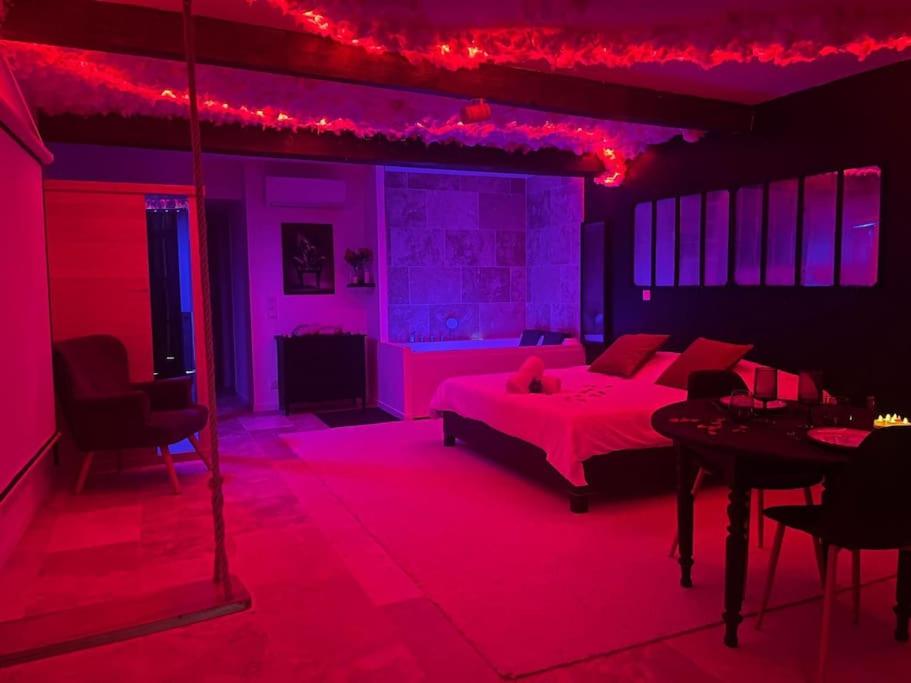 En eller flere senge i et værelse på Love Room romantique - Jacuzzi et Sauna intimes