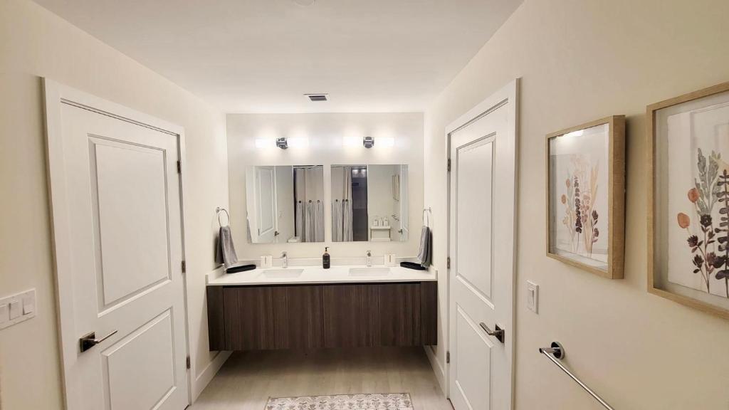a white bathroom with a sink and a mirror at NEW Modern Condo FREE Parking & High Speed Wifi in Hollywood