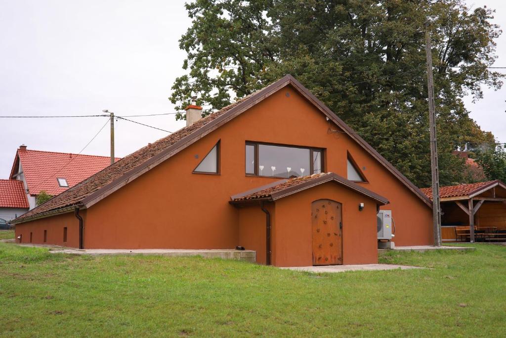 a small orange house with a door and a window at Lawki Booking in Ławki