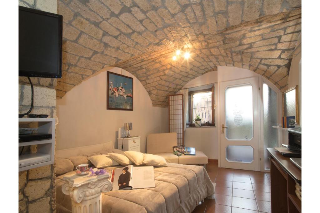 a living room with a large bed and a tv at Monolocale Il Nido in Cuglieri