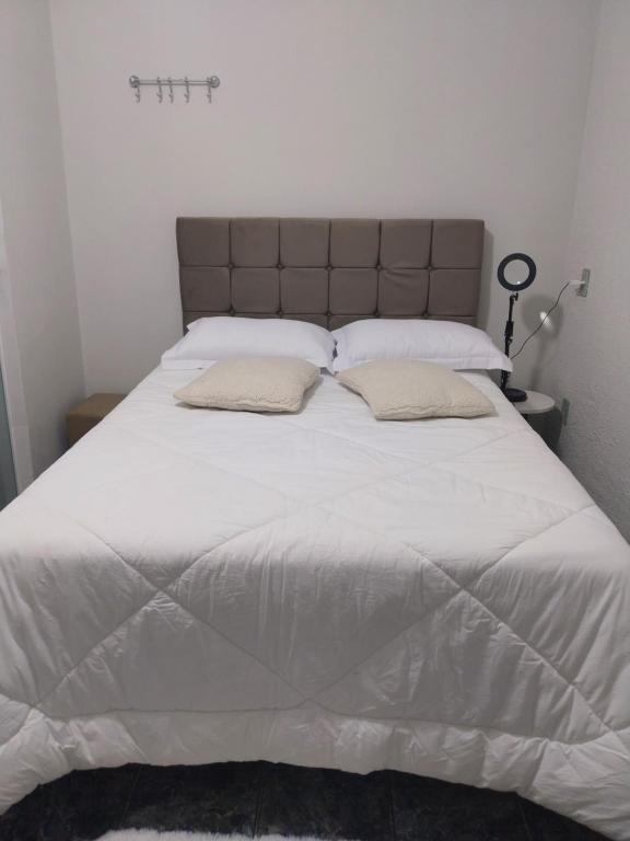 a large white bed with two pillows on it at Casa Vanuze 2 in Holambra