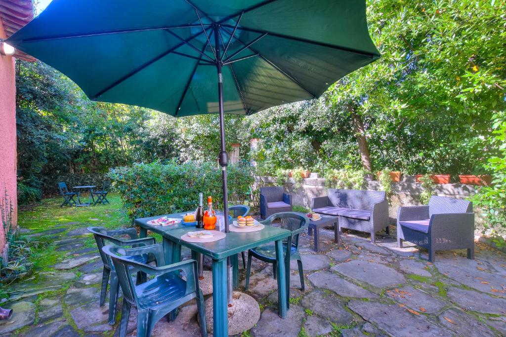 Una mesa y sillas azules bajo una sombrilla. en La Fresia - Focette 100m from sea - Happy Rentals, en Pietrasanta