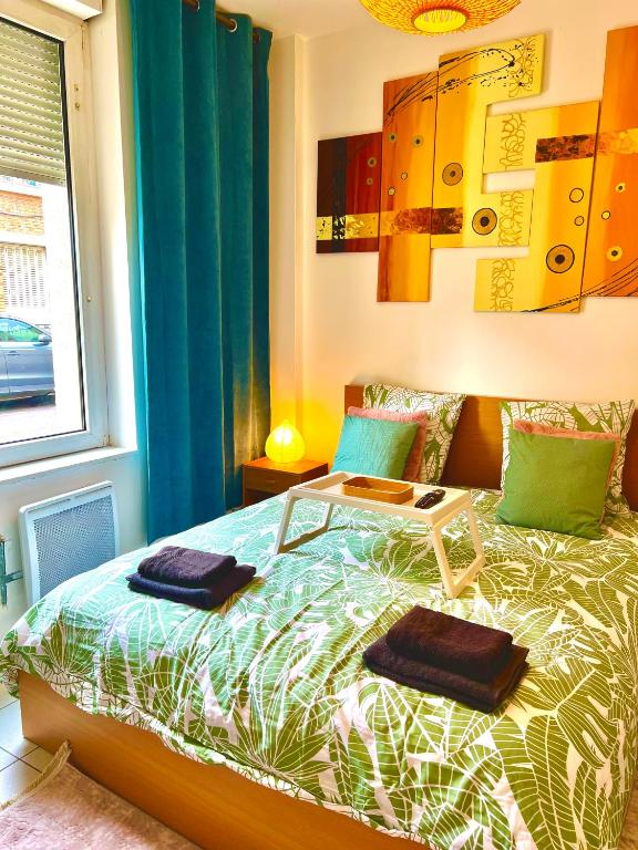 une chambre avec un lit avec deux serviettes dessus dans l'établissement Suite de charme proche de la gare-internet haut débit, à Reims