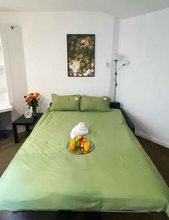 - un lit vert avec un bol de fruits dans l'établissement Studio The Champs-Élysées, à Paris