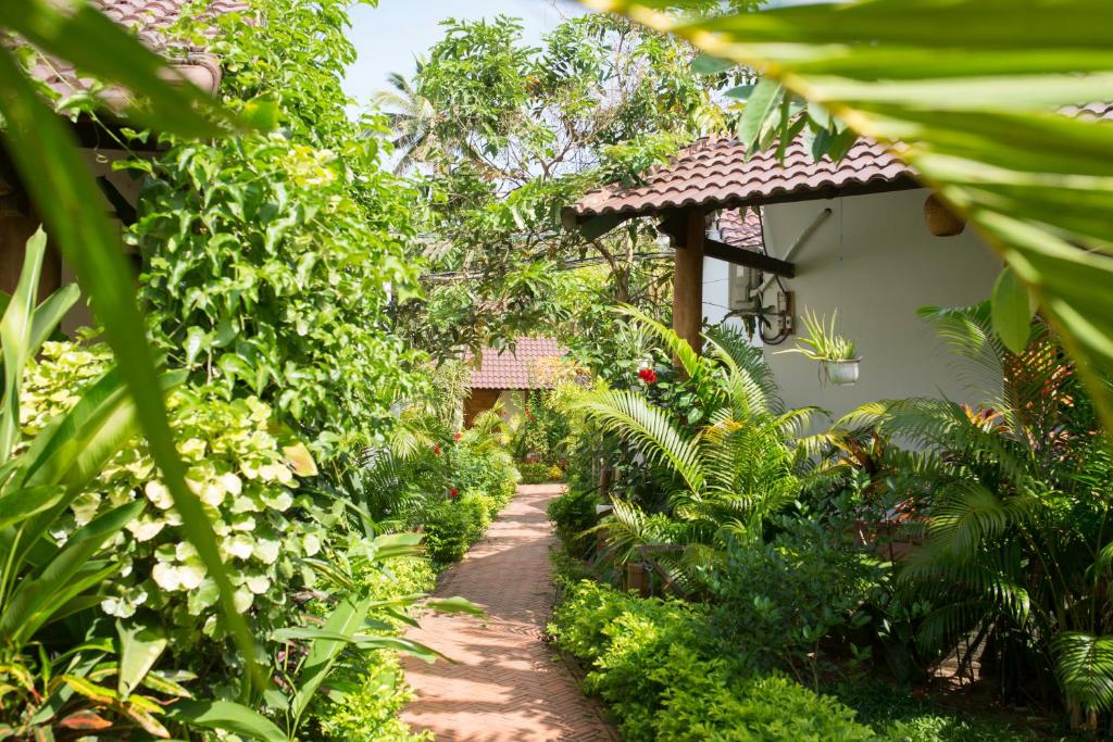 a path through a garden with green plants at La Mer Resort, Phú Quốc in Phú Quốc