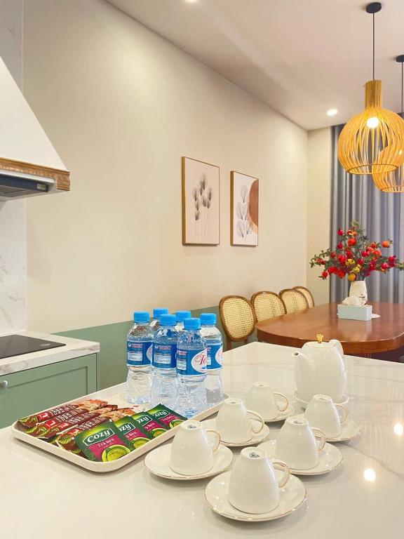 a table with plates and bottles of water on it at Villa IVY HOUSE in Bình Tú