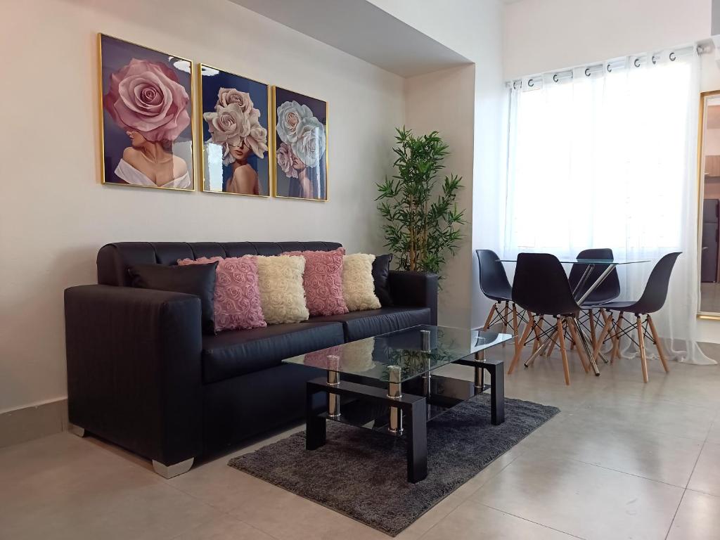 a living room with a black couch and a glass table at Boca del Mar III, apto 707 in Boca Chica
