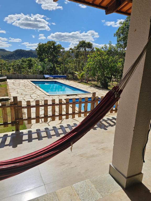 a hammock on a patio with a swimming pool at Estância Morro Do Frota in Pirenópolis