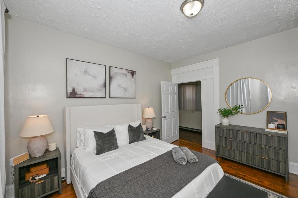 a bedroom with a large white bed and a mirror at 3 Bed Spacious 1st Floor Apt at Tremont in Cleveland