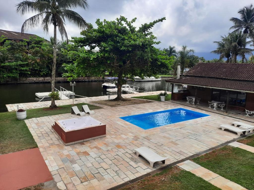 a backyard with a swimming pool and a house at Casa na Marina com piscina churrasqueira e píer in Guarujá
