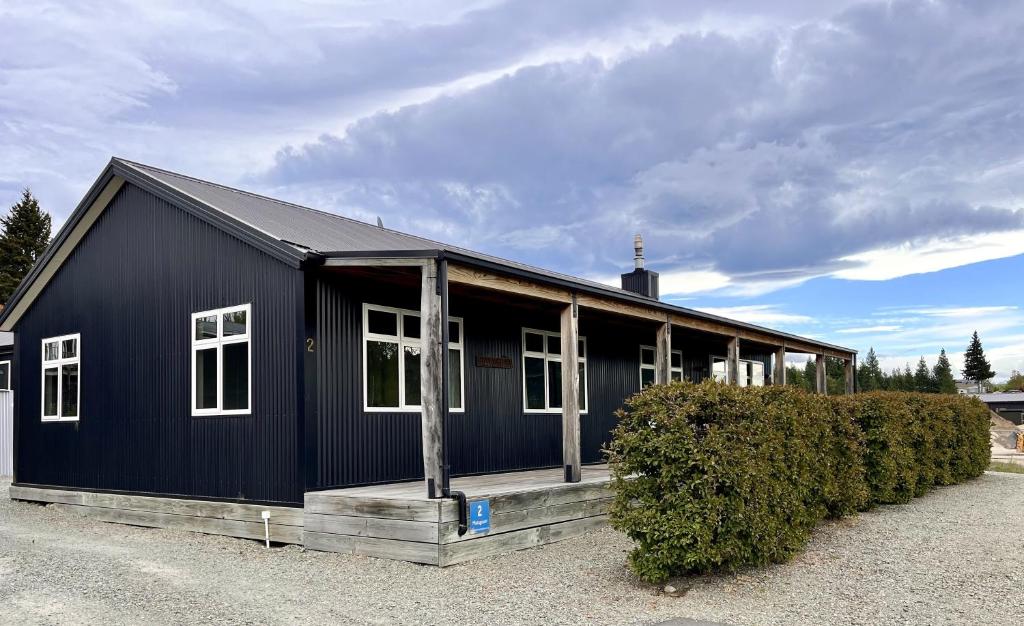 un bâtiment noir avec des fenêtres blanches dans l'établissement Matagouri Cottage - Lake Tekapo, à Lac Tekapo