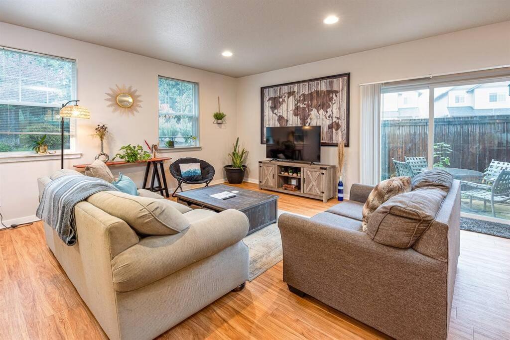 ein Wohnzimmer mit zwei Sofas und einem Fernseher in der Unterkunft TWO townhomes for your giant group! in Corvallis