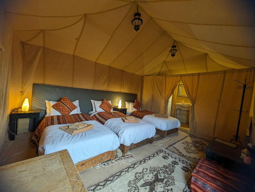 Postel nebo postele na pokoji v ubytování Erg Chebbi Romantic Desert Camp