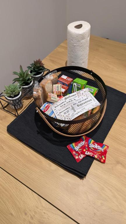 un panier de nourriture sur une table avec un rouleau de papier toilette dans l'établissement Duplex77 Near Disney, à Quincy-Voisins